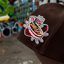 Walnut fitted hat featuring raised embroidered SF 49ers logo and a colorful 1996 Draft patch, displayed against graffiti background.