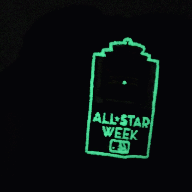 A glowing green outline of a sign reads ALL-STAR WEEK with an MLB logo below, set against a black background—an image that would look right at home on the San Francisco Giants All-Star Trolley Corduroy 19Twenty Snapback Hat in black and orange.