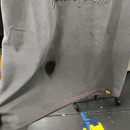 A heat gun is aimed at the SOF Watermark Script Tee in gradient grey, shrinking a wet spot and drying the fabric while the water-reactive tee hangs on a rack.