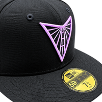 A black Golden State Valkyries 59Fifty V’s Up After Dark Fitted Hat featuring a purple geometric embroidered logo on the front crown and a gold-colored size sticker on the flat brim.