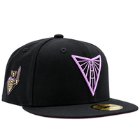 A black Golden State Valkyries 59Fifty V’s Up After Dark Fitted Hat featuring a pink triangular bridge logo on the front and a gold-toned knight emblem on the side.