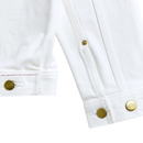 Close-up of the cuffs and lower edge of the Selvedge Pleated Denim Jacket in white, featuring gold logo-embossed buttons and detailed visible stitching.