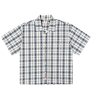 The Springdale Short-sleeve Button-up Shirt in egret and blue features a plaid pattern, spread collar, and logo tags on the chest pocket and bottom hem. Made of cotton linen, it’s shown laid flat on a white background.
