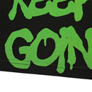 Close-up of green, graffiti-style text on black shows "KEEP GOIN'"—perfect for the Keep Goin' Tee in black, an oversized streetwear piece inspired by San Francisco's Mission District energy.