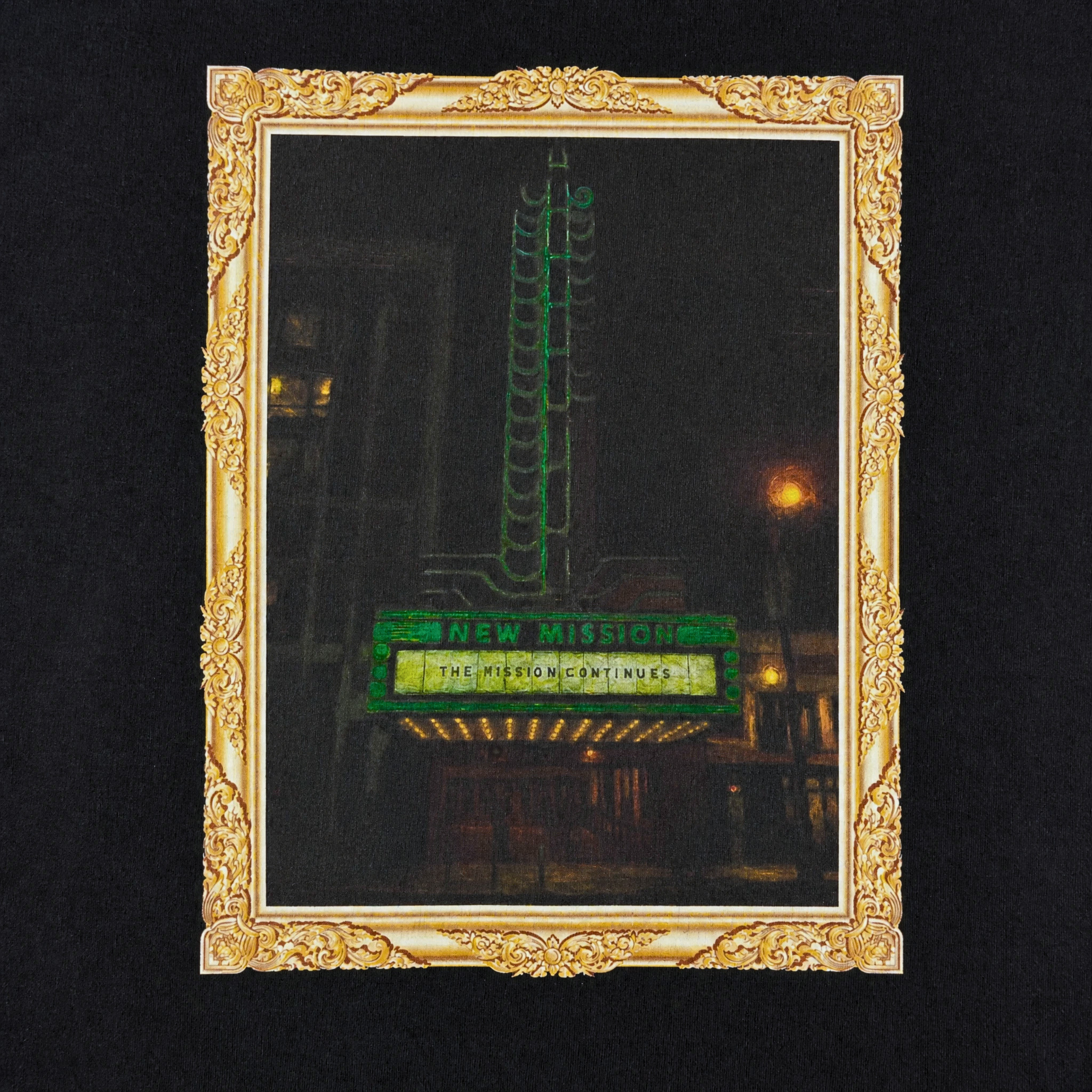 A gold ornate frame surrounds a photo of a vintage theater sign lit with green neon, reading NEW MISSION and THE MISSION CONTINUES—a classic San Francisco Mission District scene—featured on the Keep Goin' Tee in black.