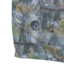 A close-up of the Love For Life Hoodie in camo by Jungles Jungles shows the pocket featuring a blurred, abstract pattern, the phrase LOVE FOR LIFE, and a faded black-and-white image of two faces printed on heavyweight fleece fabric.