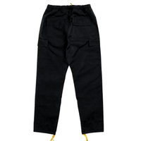 The Flux Utility Cargo Pants in black are shown from the back, featuring two back pockets, side utility pockets, an adjustable waistband, and yellow drawstrings at the ankles.
