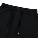 A close-up view of the elastic, adjustable waistband of the Flux Utility Cargo Pants in black, featuring a drawstring with bright yellow plastic tips and a glimpse of utility pockets.