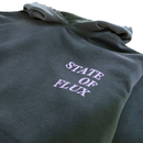 A heavyweight hoodie in distressed faded black and lilac with the words STATE OF FLUX printed in bold, light-colored letters on the chest.
