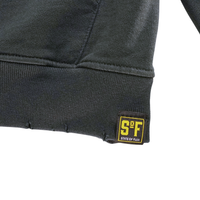 Close-up of the hem of the Today Is The Day Hoodie in distressed faded black and lilac, featuring a small yellow and black S&F STATE OF FLUX fabric tag sewn onto the lower edge.