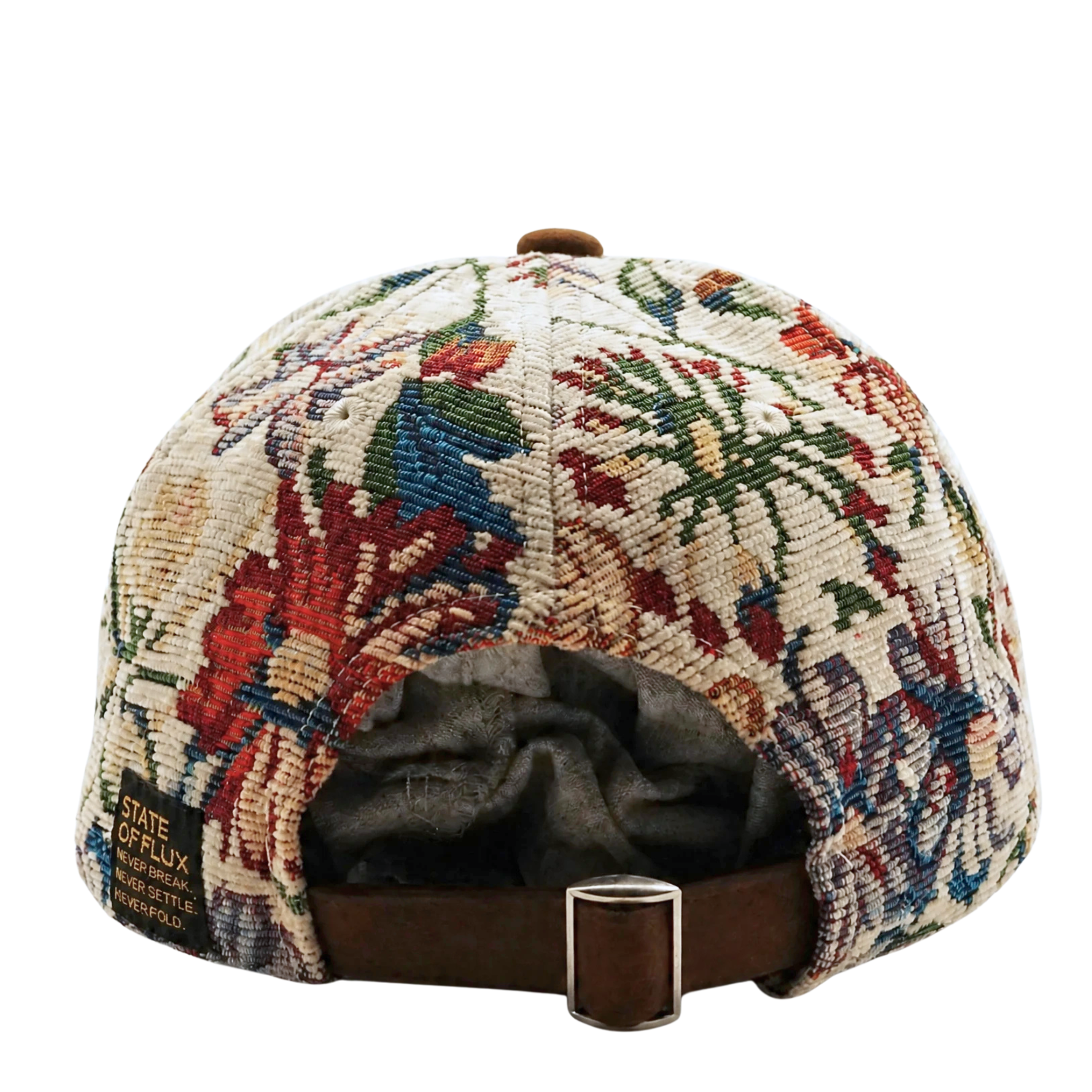 The back view of the Wildflower Strapback Hat in cream and brown reveals a vibrant floral-patterned cap with a brown adjustable strap and metal buckle, featuring a small label that reads State of Flux.