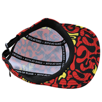 A vibrant Zippered Psycapdelic 5-Panel Hat in blood red and bright yellow is turned inside out, revealing its mesh lining and black bands labeled STATE OF FLUX.