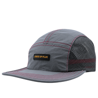 Introducing the SOF Active 5-Panel Cap in steel: a lightweight, water-resistant nylon cap featuring a gray (steel) colorway, red stitching, and a mesh back for breathability. Designed with a curved brim and sporty modern style, it’s finished with a front patch that reads STATE OF FLUX in bold yellow letters.