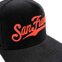 The San Francisco Giants All-Star Trolley Corduroy 19Twenty Snapback Hat in black and orange features “San Francisco” chainstitch embroidered in bold orange script on the front, inspired by classic Giants snapback designs.