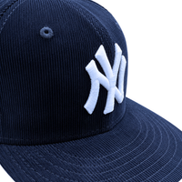 A close-up of the New York Yankees Seinfeld Corduroy 59Fifty Fitted Hat in navy and white, featuring an embroidered white New York Yankees logo on the front panel.
