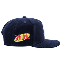 New York Yankees Seinfeld Corduroy 59Fifty Fitted Hat in navy and white, featuring a yellow and red Seinfeld logo embroidered on the side. This fitted New Era cap is displayed from a side angle against a white background.