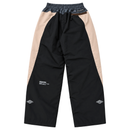 Disorder Track Pants in black and beige nylon featuring an elastic waistband, a zippered back pocket, and white graphic text on the lower legs.