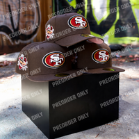 Fitted San Francisco 49ers T.O. Pinky hat in walnut with raised embroidered logos and a pink underbill, stacked on a black pedestal.