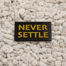 Never Settle enamel pin 1.25in black and yellow soft enamel dual post with black rubber backers